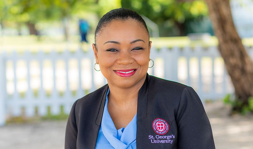 Smiling woman wearing a black blazer embroidered with the St. George's University logo News