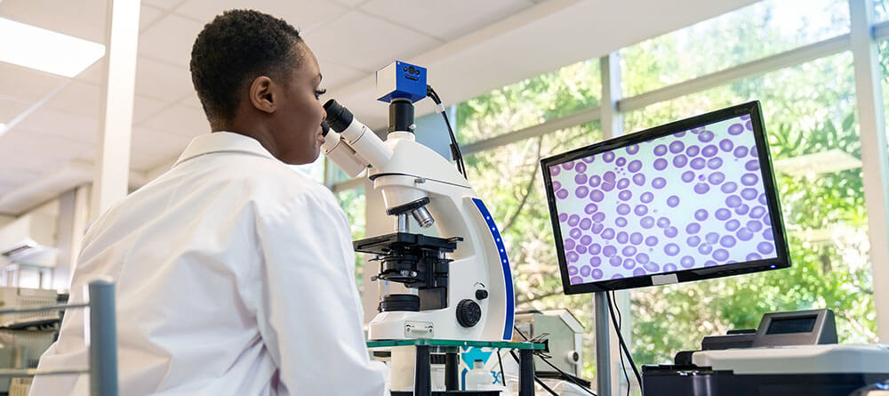 A pathologist reviews cells on a monitor
