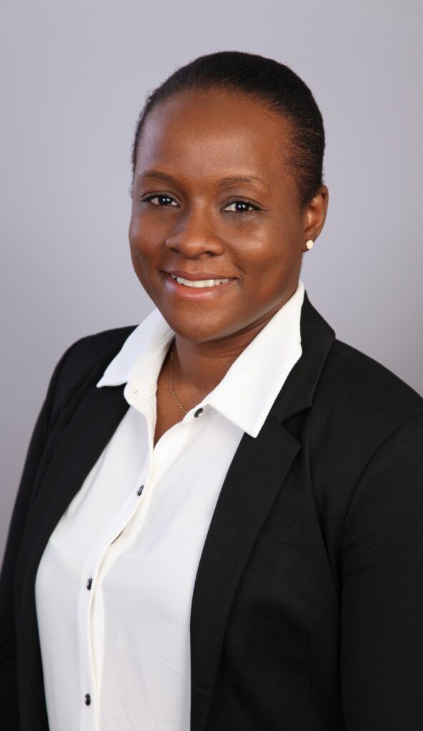 Smiling woman with short hair wearing a black blazer over a white collared shirt
