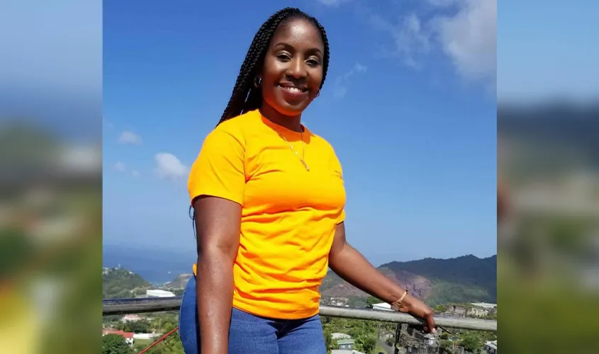 SAS Student Gillian Francis, balancing parenthood and business degrees, smiles against a scenic outdoor background.