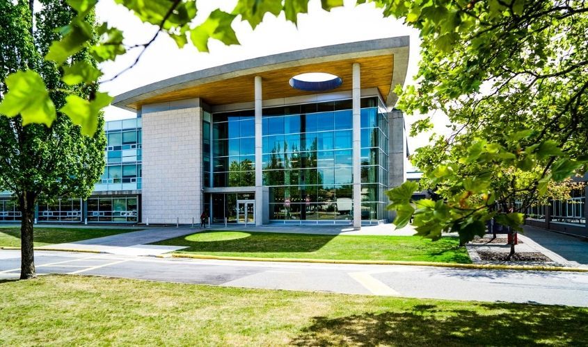 Kwantlen Polytechnic University (KPU) Surrey campus modern glass and brick main building on a sunny day in Canada.