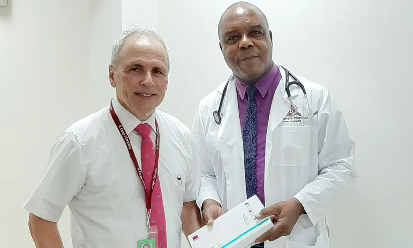 Two St. George's University medical professionals standing together and holding a medical testing kit box News