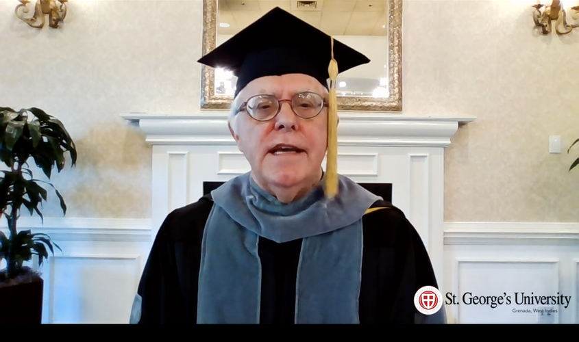 Speaker in academic regalia delivering a video address for St. George's University