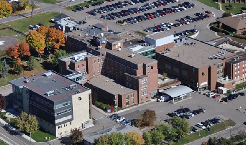 Aerial view of a hospital complex and parking lots, with building sections labeled A, B, and D News