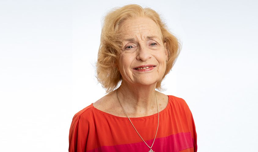 Elderly woman with short blonde hair smiling gently against a white background News