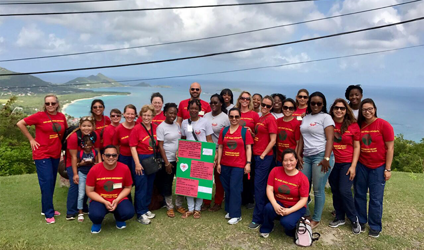 A San José State University interdisciplinary health care team poses together on a hill overlooking a tropical coastline News