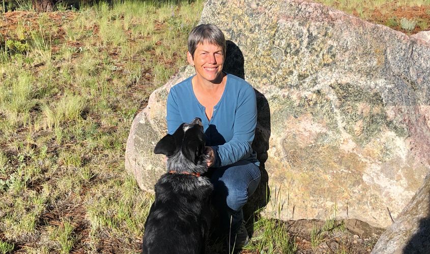 Dr. Stacey Byers, SGU Vet Med professor specializing in large animal internal medicine, smiling outdoors holding a dog