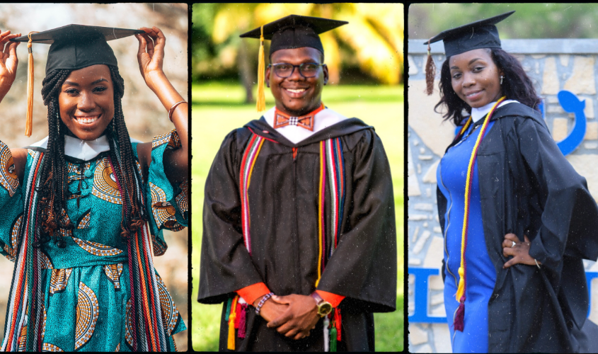 Three smiling graduates posing in graduation caps, gowns, and colorful academic stoles