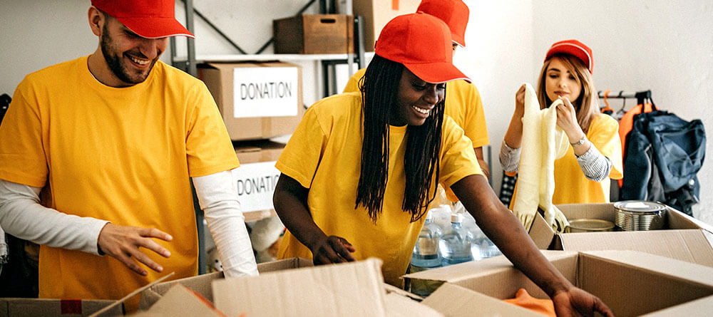 A group of volunteers help package up donation boxes for a charity