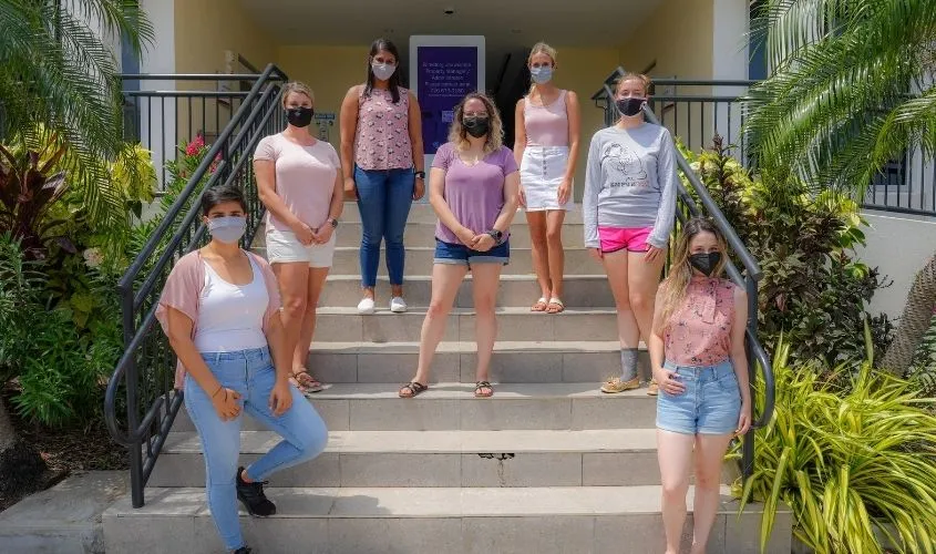 A group photo of members from the St. George's University Women in Medicine (WIM) Club promoting a health awareness campaign or student event in 2021. News