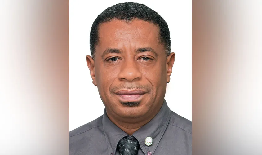 Headshot of a man wearing a grey collared shirt and dark tie News
