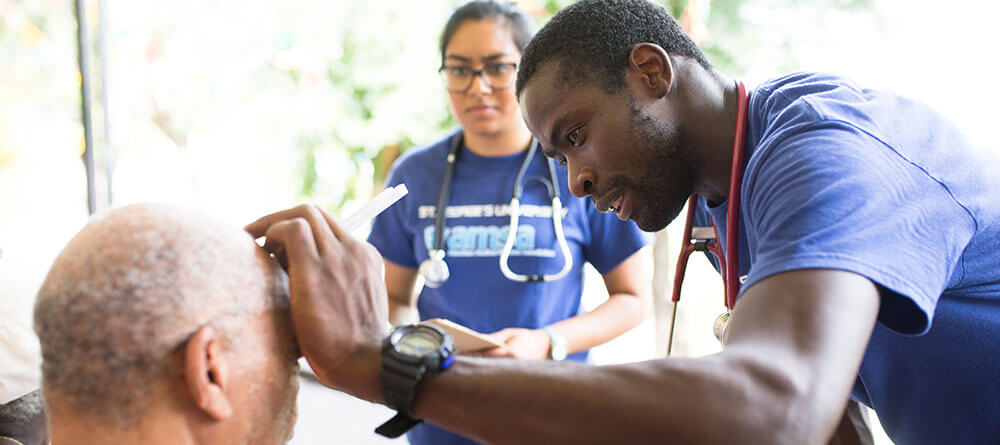SGU medical students examine a patient during a community outreach event