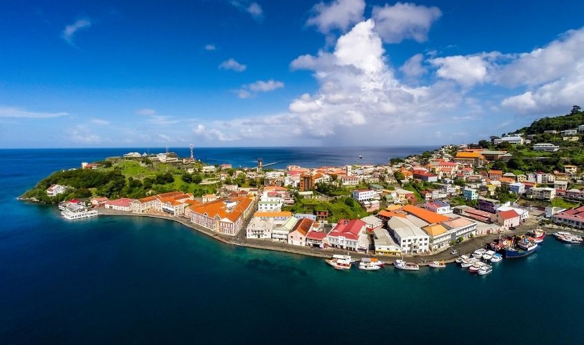 Lush green mountainous landscape of the tropical island of Grenada with coastline and clear blue Caribbean sea. News