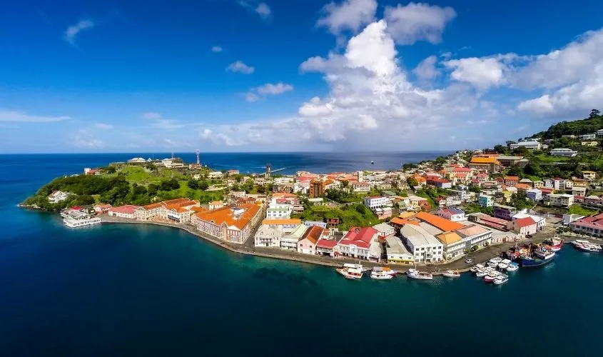 Lush green mountainous landscape of the tropical island of Grenada with coastline and clear blue Caribbean sea.