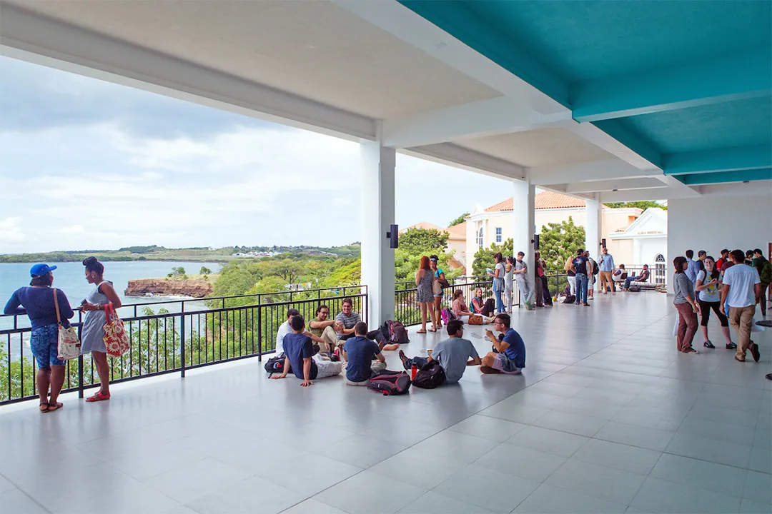 Students relax between classes in the open air of Modica Hall at SGU