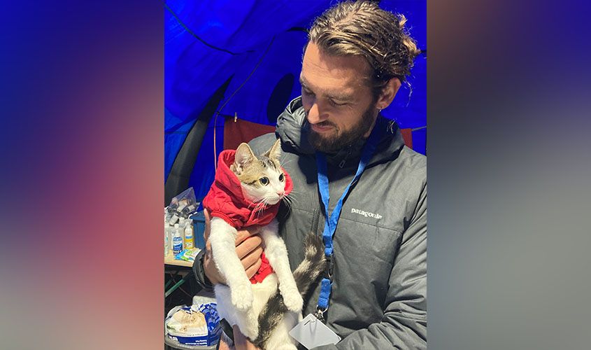 Dr. Andrew Kushnir, SGU DVM alumnus, holding a cat in a carrier at a refugee support center near the Ukraine border.