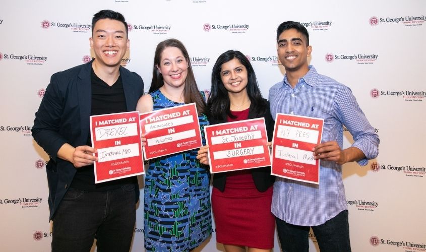 Medical students celebrating and cheering at the 2019 Match Day event, holding up envelopes with their residency results. News