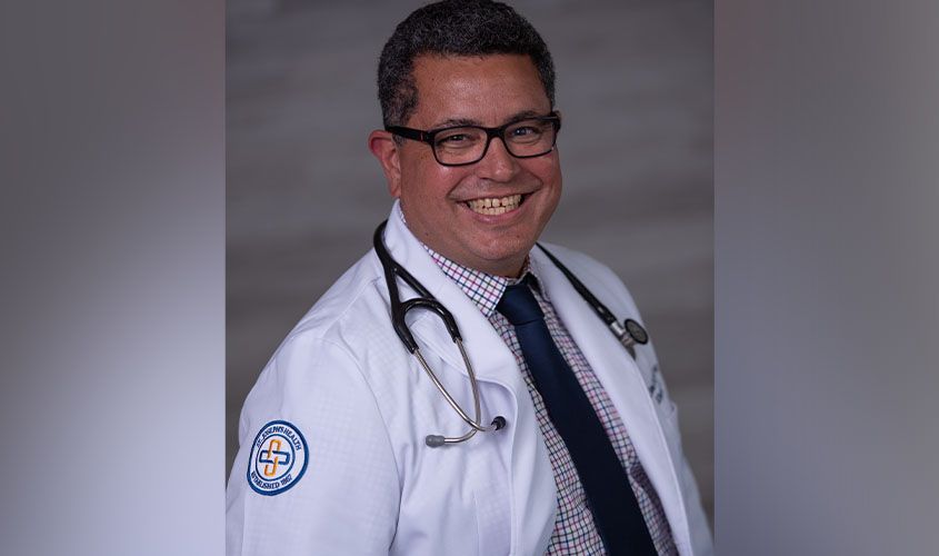 Smiling doctor wearing glasses, a stethoscope, and a white lab coat with a St. Joseph's Health patch
