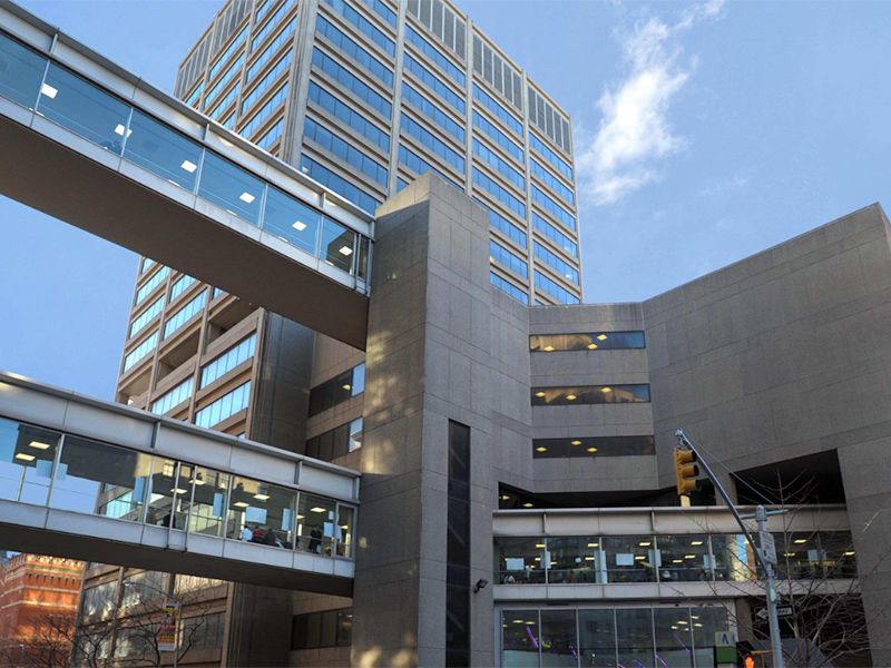 Glass pedestrian skywalks connecting multi-story concrete buildings against a blue sky