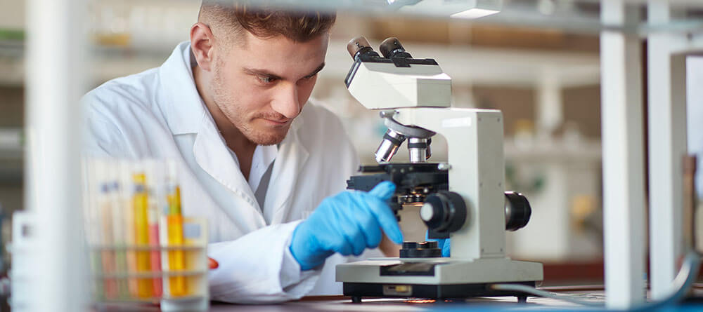 A medical student uses a microscope in a classroom laboratory
